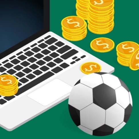Laptop och fotboll med pengar att investera bredvid